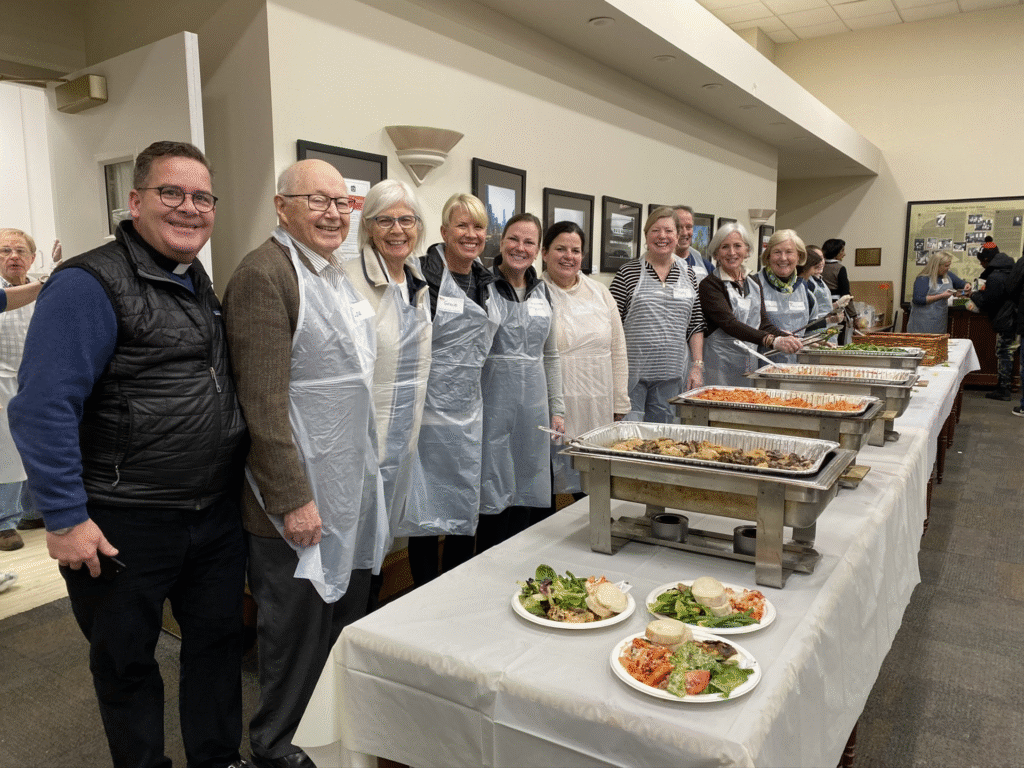 Volunteers lined up with aprons waiting to serve meals