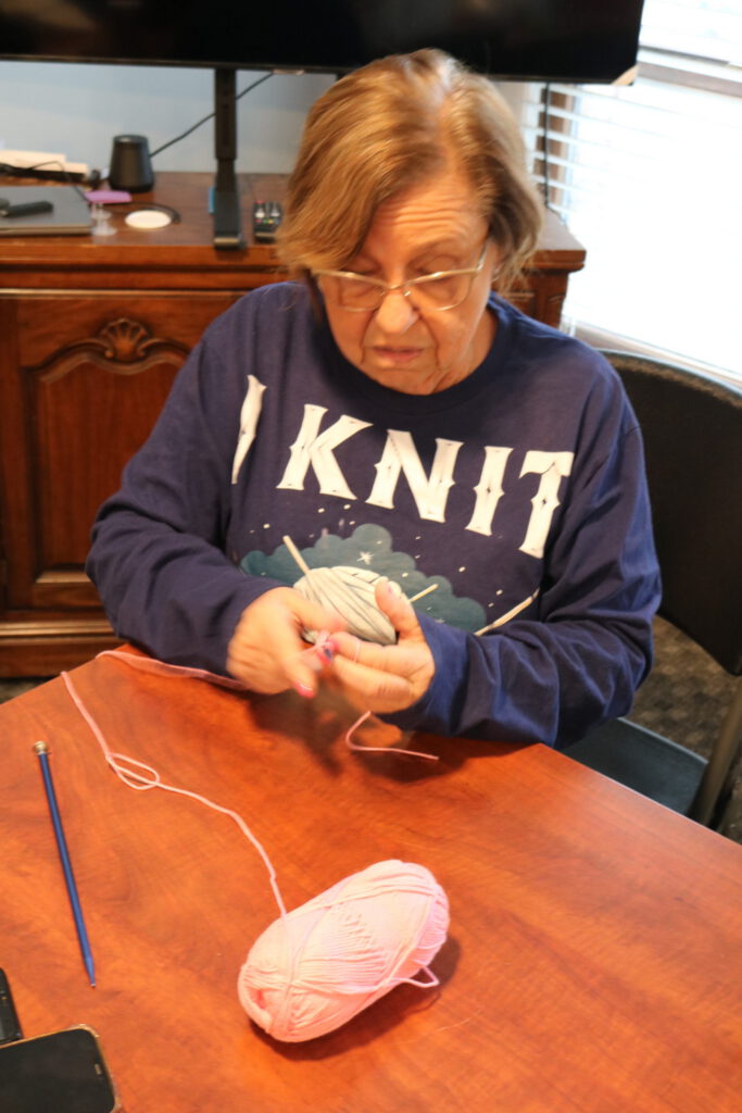 Woman knitting with pink yarn