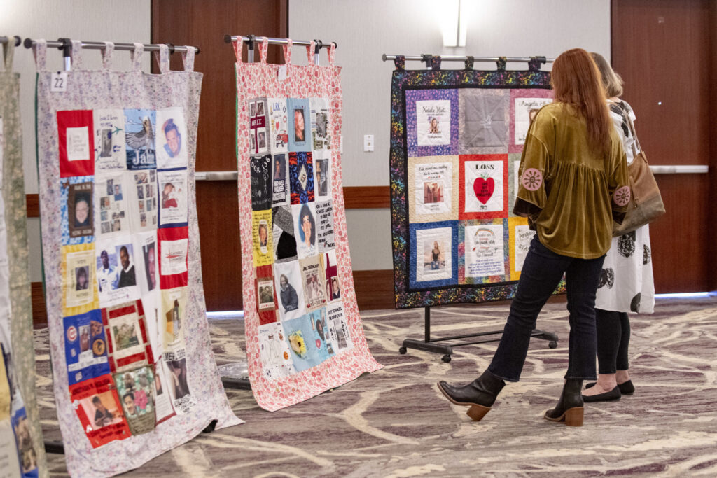Women observing quilts during the Blossoms of Hope Brunch 2025