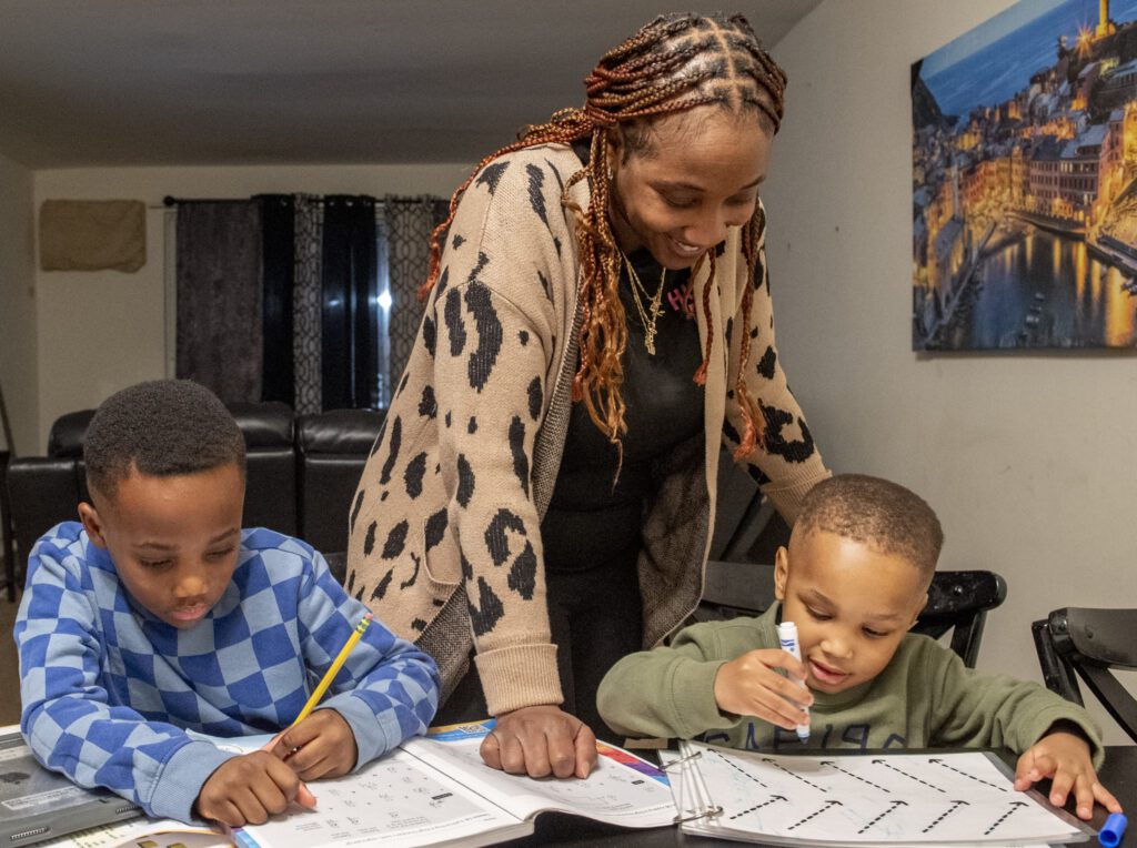 Mother watching over her sons as they work on their homework
