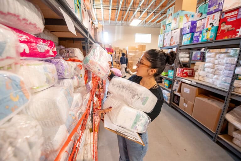 Volunteer organizing diapers at Diaper Depot