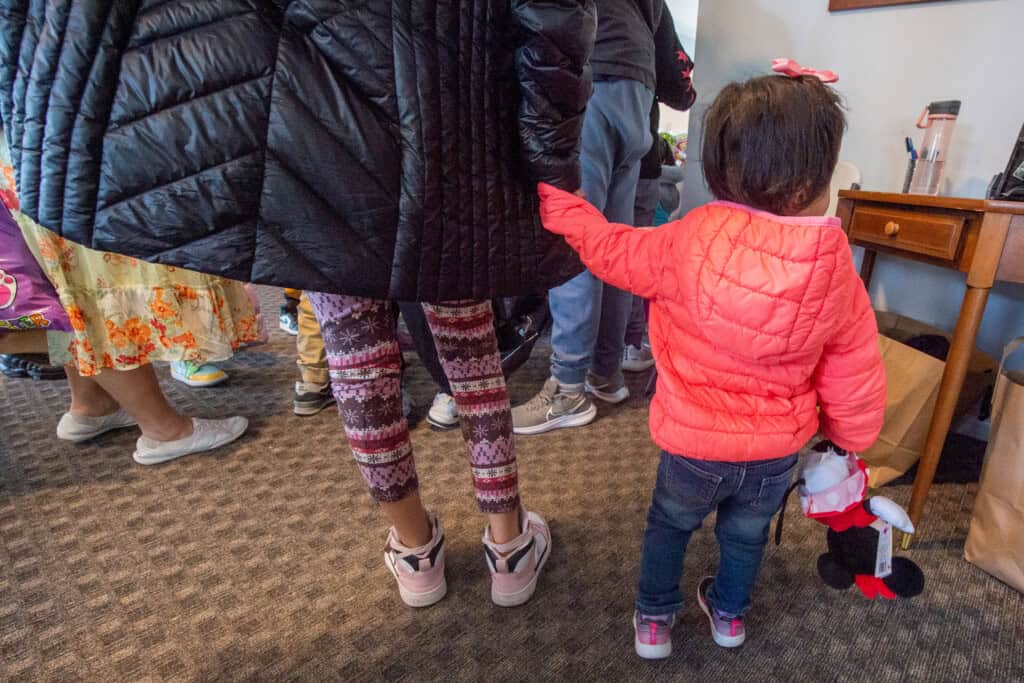 Mother and child holding hands during an Easter Egg Hunt at the House of Good Shepherd residential domestic violence shelter