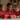 Three children wearing Christmas pajamas opening gifts on Christmas morning