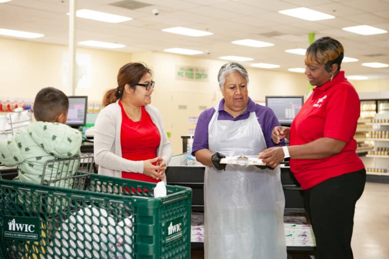 Employee/volunteers/customers interacting at WIC grocery store