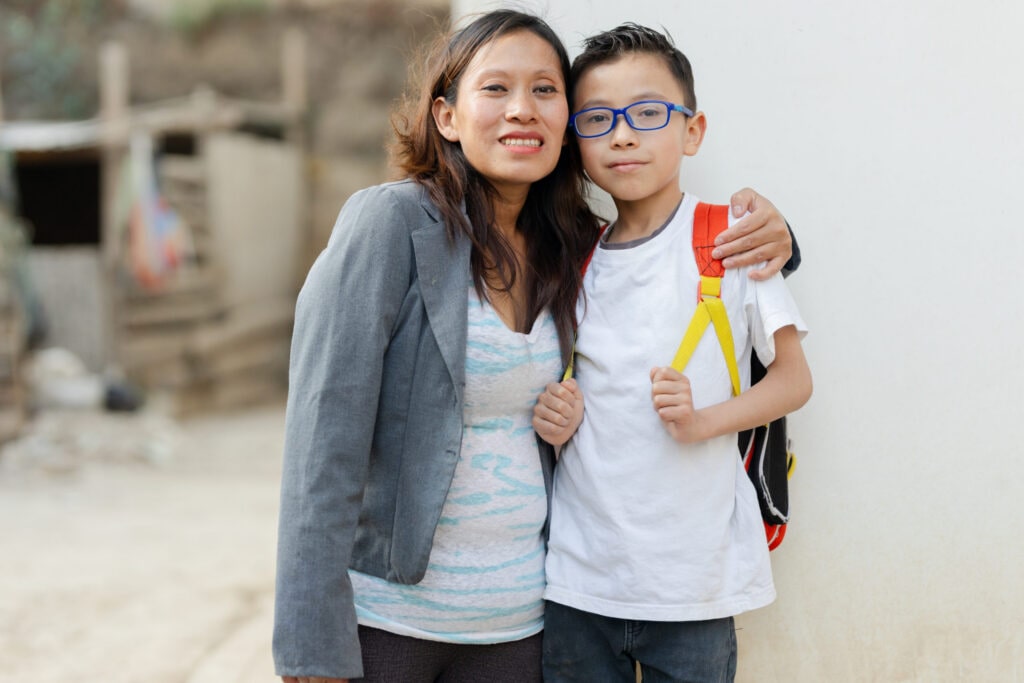 Portrait of mother and son ready to go to school. Hispanic mother and son outside school.
