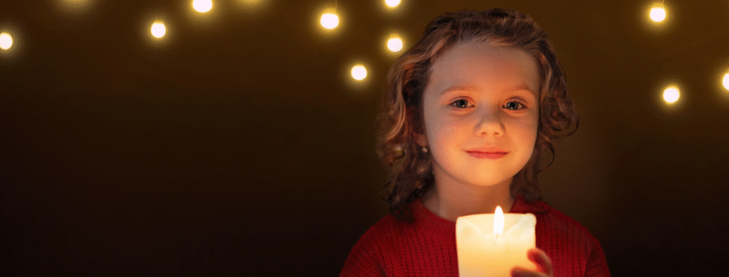 Child holding a lit candle