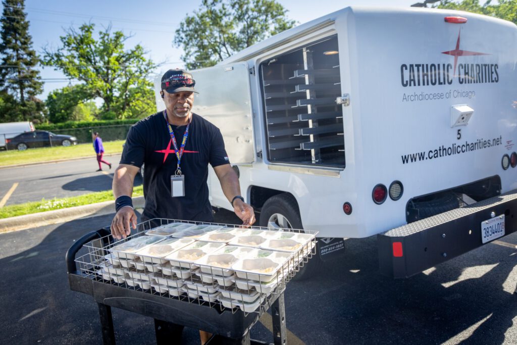 Meals on Wheels volunteer loading meals onto cart