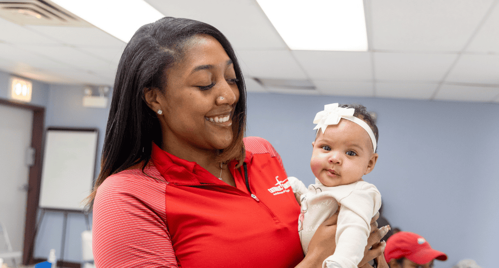 Doula Keiona Johnson holds a baby.