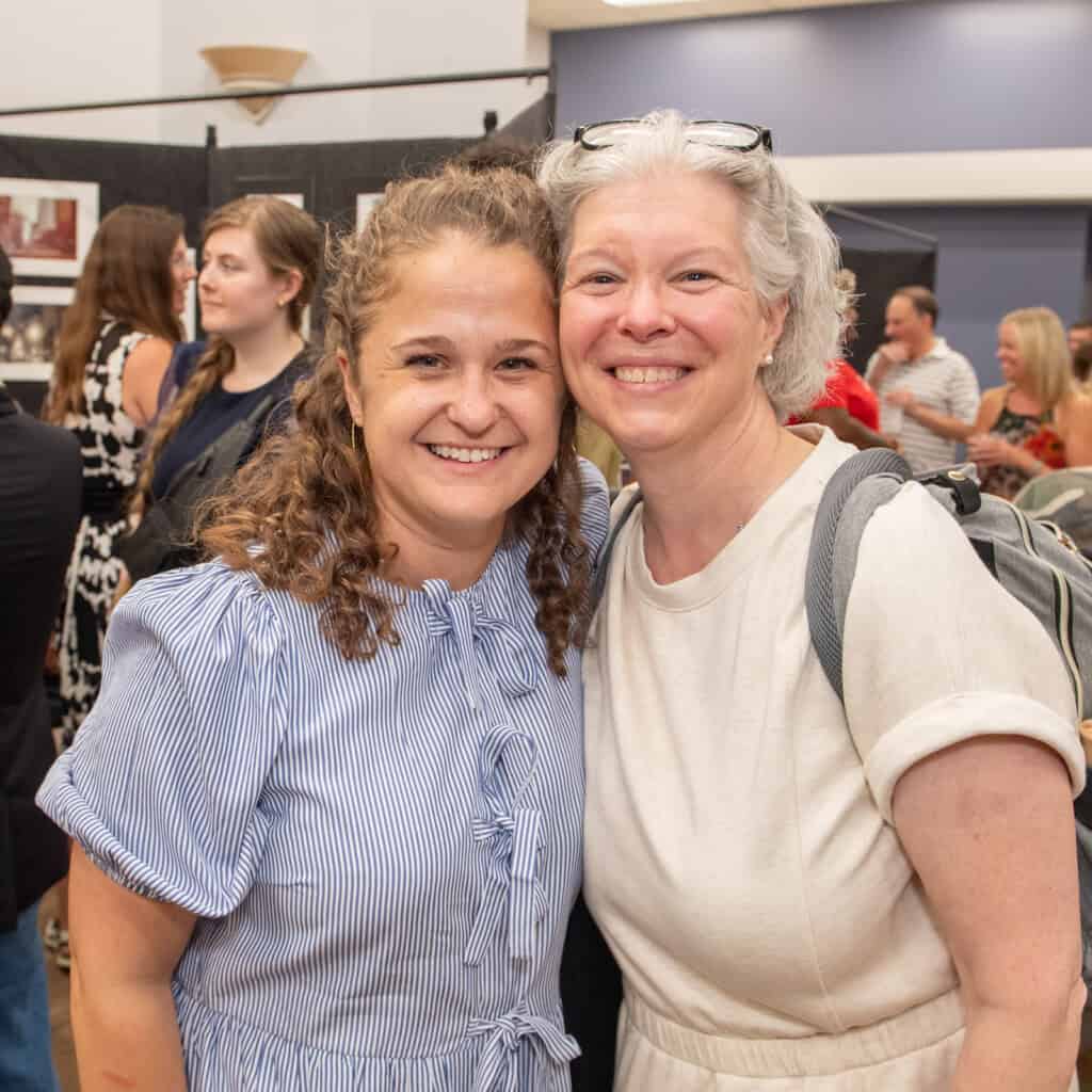 Two women smiling at exhibition and reception for the artists of the After Supper Visions program