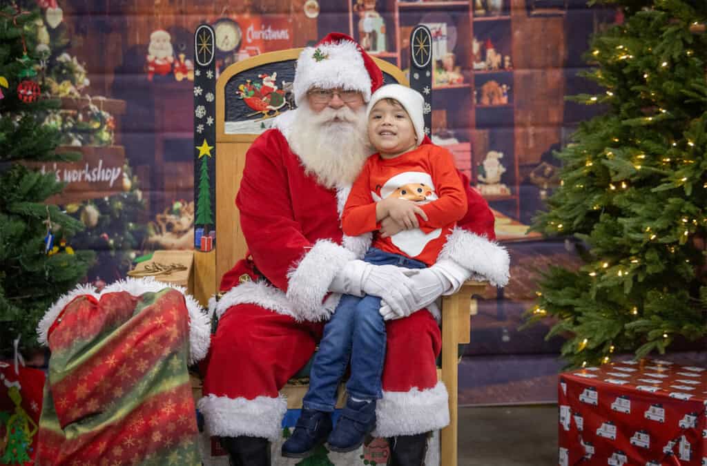 A Christmas Blessing at the Celebration of Giving. Child poses with Santa