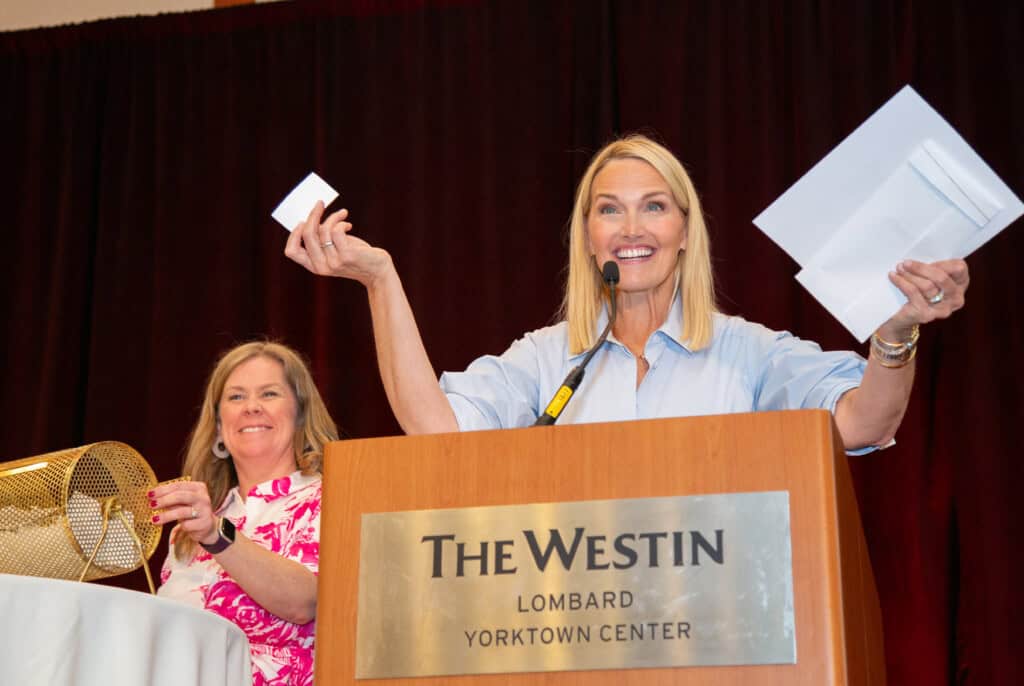 Woman announcing raffle picks at Blossoms of Hope Brunch