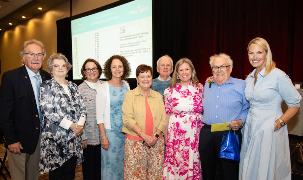 Father Rubey Smiling with attendees of Blossoms of Hope Brunch