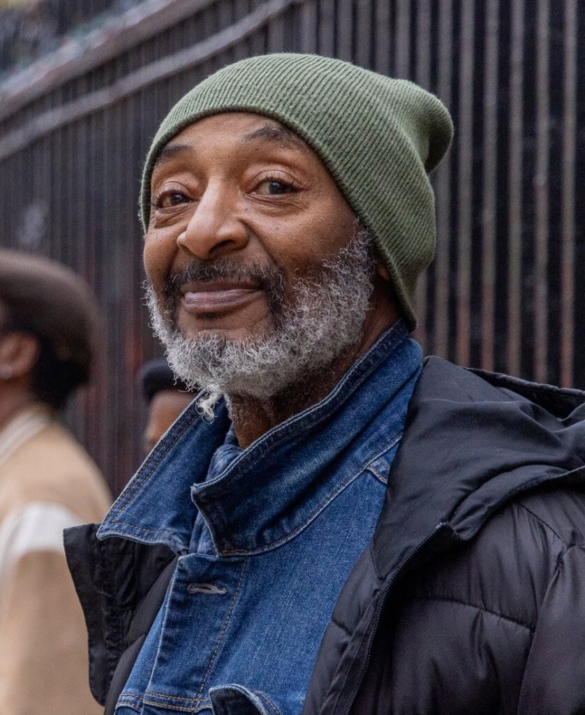 Man Smiling standing in line outside of Catholic Charities