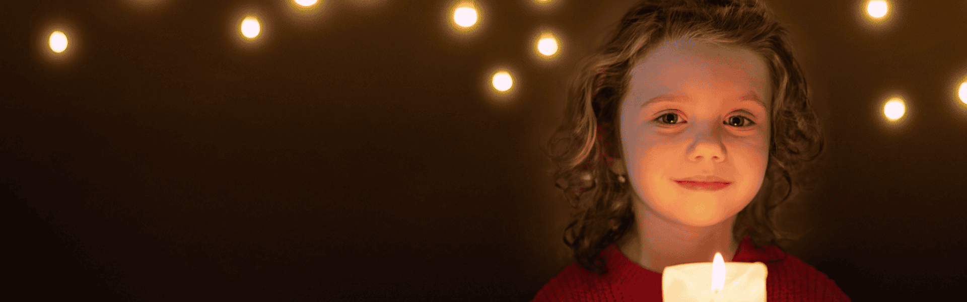Child holding a lit candle banner
